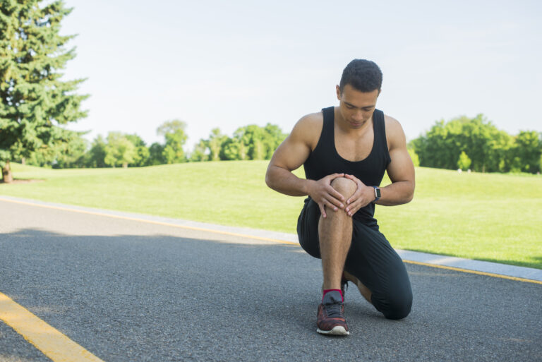 Athlete holding his knee after an ACL injury during exercise